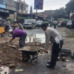 Personel Satlantas Polres Gowa Kerja Bakti Timbun Jalan Berlubang